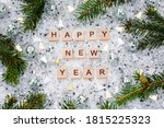 Happy new year 2021. Wooden letters with silver balls,silver confetti and with green branches of a Christmas tree on a white background. Flat lay.