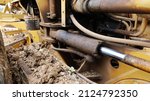 Small photo of Dirty hydraulic piston system. The hydraulic piston of a heavy industrial vehicle is leaking and dirty with nasty oil stains. Selective focus
