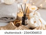 Cozy corner for home meditation and relaxation. Fall aroma diffuser with pumpkin pie scent, cinnamon, orange, burning candles for comfort, pleasure, aromatherapy. Apartment decor, house design