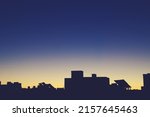 Silhouette of the top of a modern building in Madrid, Spain. Silhouette of the solar panels and chimneys located on the roof with the first rays of the sun in a yellow and blue sky.