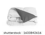 Folded soft white duvet, blanket or bedspread with the gray back side and empty white label, against white background. Close up photo