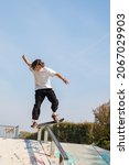 Small photo of teenager doing stunts with his skateboard