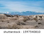 USA, Nevada, Clark County, Tule Springs Fossil Beds National Monument: White gypsum hills with Mt. Charleston in the distance.