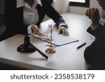 Lawyer meeting contact us concept: Lawyer businessman and woman working together with law book at desk in office, justice and law, attorney.