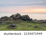 rocky cliffs edge over ocean sunset
