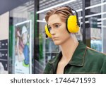 Male mannequin in work clothes with yellow anti-noise headphones on his head.