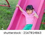 Small photo of Portrait image of 4-5 yeas old baby. Happy Asian child girl smiling and laughing. She playing with slider bar toy at the playground. Learning and active of kids concept.
