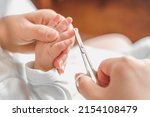 Small photo of mother cuts baby's fingernails with special children's scissors. close up. manicure for newborns.