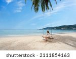 Young woman traveler enjoying on the swing at beautiful tropical white sand beach, Summer vacation and Travel concept