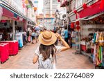 Young female tourist walking in Chinatown street market in Singapore