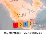 A block with 2023 written on it and a map and flag of United States.