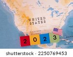 A map and flag of United States with a block with 2023 written on it.