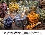 Glass jars of dry lavender and calendula flowers. Jars of dry medicinal herbs for making herbal tea, bunch of dry lavender on table. Alternative medicine.