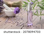 Small photo of Spray bottle of lavender essential oil. Scented lavender water, serum, flavored water. Lavender flowers on background. Aromatherapy. Natural cosmetic beauty care product. Alternative herbal medicine.