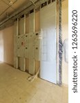 Small photo of long light corridor in residential building with Distribution board (panelboard, breaker panel, or electric panel) is component of electricity supply system that divides electrical power feed