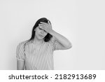 Small photo of young Asian woman on a white background holding her head, headache or migraine. concept of problem and difficult task, business. predicament fear and confusion