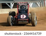 Small photo of Indianapolis, IN, USA - May 22, 2014: Racer Caleb Armstrong powers his USAC Silver Crown car through a turn on the Indiana State Fairgrounds mile. Car slightly blurred to show speed and action.