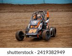 Small photo of Kutztown, PA, USA - May 24, 2023: Gunner Pio wrestles his 600cc Micro Sprint race car around a small dirt track in Pennsylvania. Car slightly blurred to show speed and action.