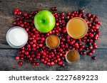 Apple Cranberry Sauce with Cider  Cinnamon on a Wood Background: Fresh cranberries, apples, and other ingredients for cranberry sauce