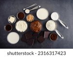 Chocolate Hazelnut Mousse Cake Ingredients on a Dark Background: Hazelnut spread, dark chocolate, cream, and other cake ingredients