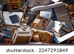 Small photo of Trash dump with old worn out mattresses, armchairs and other broken furniture of various shapes and colours.