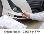 Small photo of Insurance concept, insurance agent checking broken car and submit a claim form after an accident traffic accident