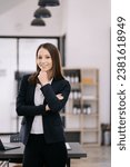 Small photo of portrait of a business woman Self-confident young woman standing holding coffee mug and working tablet. People. Straightforward portrait.