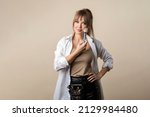 Small photo of Portrait of Makeup Artist with Belt Bag Hold Tassels Over Beige Background. Attractive Young Woman with Makeup Brushes and Thigh Bag. Beauty Blogging Concept. Make up Courses. Self Visage Masterclass