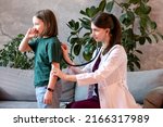 Small photo of Auscultation Lungs Exam with Stethoscope. Child Girl Visiting Doctor for regular checkup. Friendly Woman Pediatrician in Pediatric Medical Office with Young Female Patient