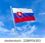 Flag on Slovakia flag pole and blue sky, Flag of Slovakia fluttering in blue sky big national symbol. Waving blue white and red Slovakia state flag, Independence Constitution Day.