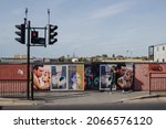 Small photo of London, United Kingdom - 19 October 2020: woman walking past posters for movie Rebecca in Fulham, London