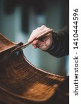 Small photo of hands of artisan luthier varnishing, building a double bass