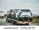 Small photo of Tow truck with broken car on country road. Tow truck transporting car on the highway. Car service transportation concept.