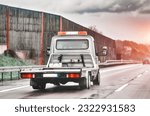 Small photo of Empty flatbed tow carrier truck. empty car carrier and flatbed tow truck vehicle travelling on a national road
