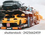 Small photo of A fleet of brand new exotic luxury sports cars ready to race or dazzle. They are loaded on a two-level hydraulic trailer truck that transports them safely and swiftly on the highway.