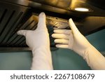 Small photo of Someone hands trying to removing a filters from cooker hood for cleaning it. Clean your filters every two to three months, depending on your cooking habits.