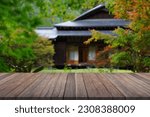 Wooden table top with blurred garden and japan house.	      