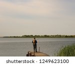 A Lone Fisherman Standing With...