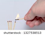 Small photo of hand with a lit match ignites matches. Concept: International match day, teamwork, team, self-sacrifice, symbol.