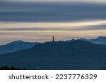 Panoramic scenic view of the viewing tower Pyramidenkogel and the snow capped Karawanks mountain range near Techelsberg, Carinthia (Kaernten), Austria, Europe. Winter wonderland in the Alps