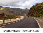 Empty curvy winding mountain road in the remote village of Afur on Tenerife, Canary Islands, Spain, Europe, EU. Panoramic view on mountain peak Roque de Taborno in Anaga massif. UNESCO biosphere park