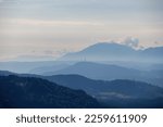 A panoramic view on endless mountain chains in Carinthia, Austrian Alps. The mountains are shrouded in fog. In the distance you can see the viewing tower Pyramidenkogel. Serenity and calmness