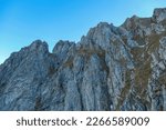 Massive rock wall of mount Eisenerzer Reichenstein in Styria, Austria, Europe. Austrian Alps. Bare and sharp mountain ridges of the Ennstaler Alps. Extreme climbing, mountaineering adventure. Sunny