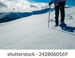 Close up view of person wearing snow shoes and walking in white fluffy snow on alpine meadow in Kor Alps, Lavanttal Alps, Carinthia Styria, Austria. Winter wonderland in Austrian Alps. Sport equipment
