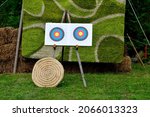 A close up on a modern target and one made out of wicker being used on a shooting range for bow and crossbow practice seen on an empty field covered with grass on a sunny summer day in Poland