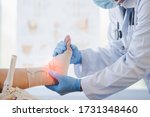 Small photo of Close-up of pictures of a male orthopedic doctor or orthopedic doctor Wear a medical mask and medical gloves. Going to analyze the cause of ankle bone degeneration In his office at the hospital