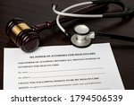 Small photo of Power of Attorney for health care, HCPA, with gavel and stethoscope. Concept of planning for death, final wishes, terminal illness, and advance directive