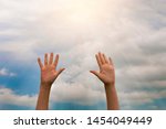two women hands reach for the sunlight against the blue sky with clouds