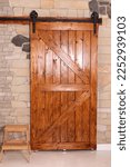 Small photo of Sliding barn wooden door in indoors. Sliding old Barn Door in modern room. Rustic farm wood sliding barn style door at home.