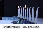Small photo of Chanuka candles with shamash lit and the first candle with Star of David coins and decorations